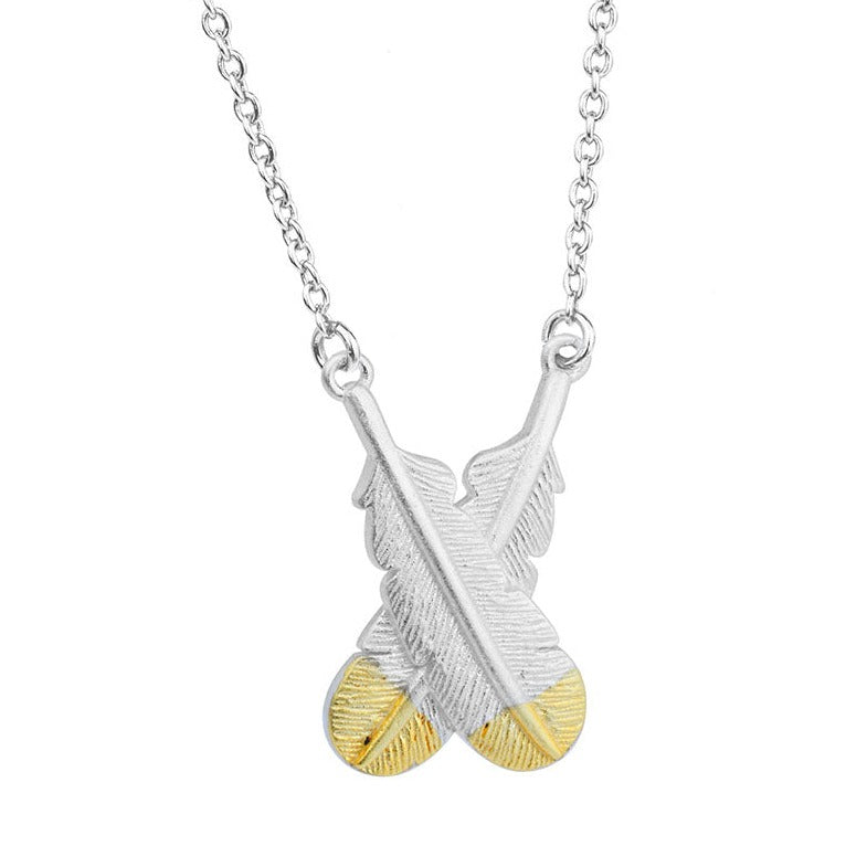 Silver pendant necklace with two overlapping huia feathers. The feathers are 3D and have gold tips. 