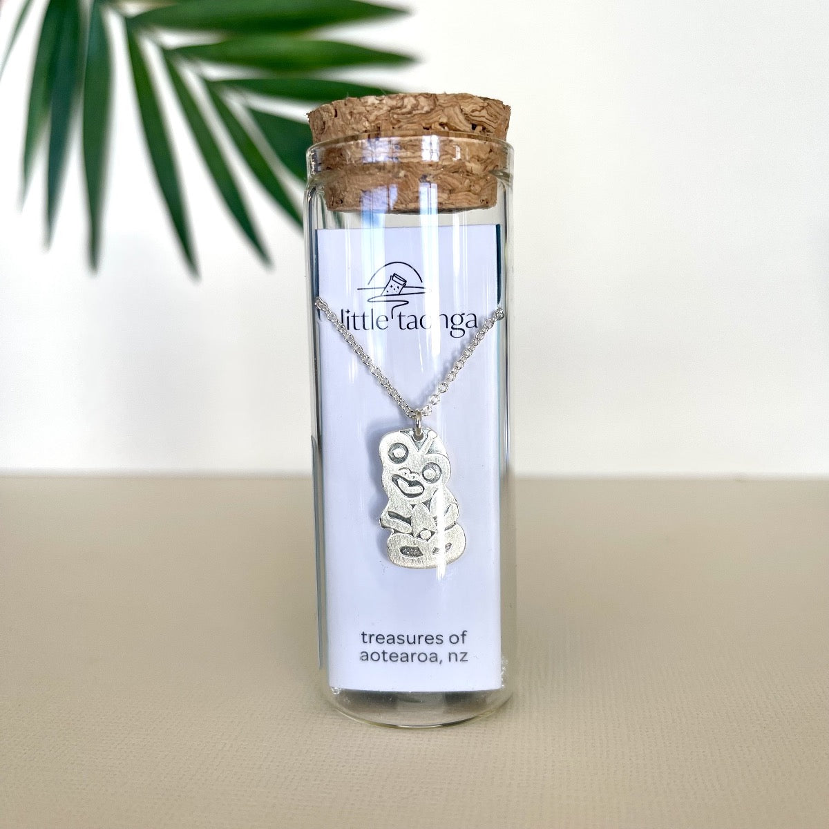 Silver Tiki Necklace in a glass bottle 