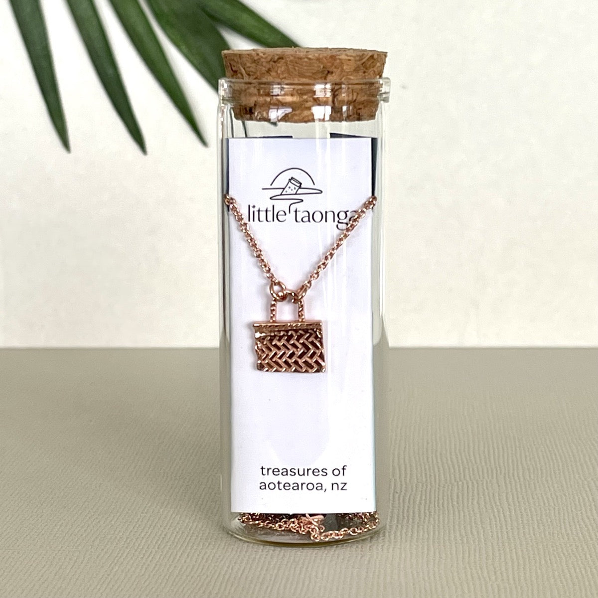 Rose Gold Kete necklace in a glass bottle