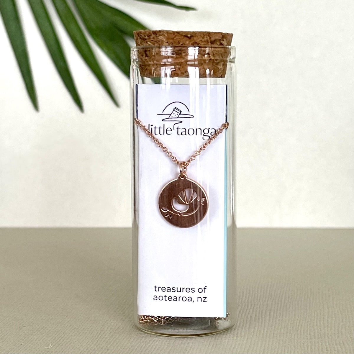 Rose gold entail necklace in a glass bottle